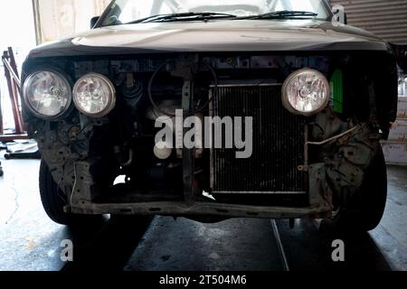 Front view of old car in repair shop. Selective focus. Stock Photo