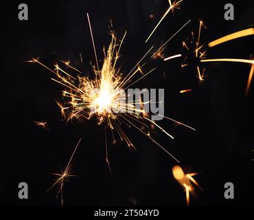 Burning sparkler light on black background. New year party background. Overlay of  New Year sparkles. Stock Photo