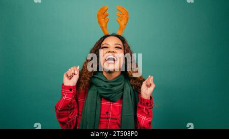 Excited young woman jumps and dances excited for Christmas, studio Stock Photo