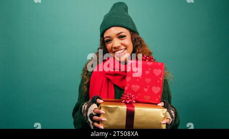 Beautiful young woman holding pile of presents, wrapped Christmas gifts Stock Photo