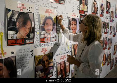 Tel Aviv, Israel. 01st Nov, 2023. A woman writes a message on the photographs of the people kidnapped by Hamas during the demonstration. Dozens of relatives and friends of the people kidnapped by Hamas on October 7, demonstrated peacefully in the city of Tel Aviv. These demonstrations were made after the Israeli government recognized that 7 of the hostages were killed after one of their incursions into the Strip. Protesters are calling on the government to act to bring their loved ones back safely. Credit: SOPA Images Limited/Alamy Live News Stock Photo