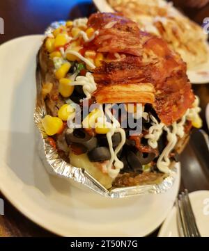 Stuffed potato kumpir on plate fully stuffed Stock Photo