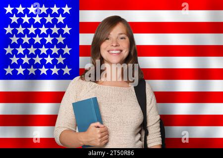 Happy young woman student standing against US flag background. Travel, education and learn english language in USA concept Stock Photo