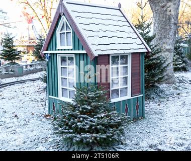 Small house with a fir tree on a winter snow day Stock Photo