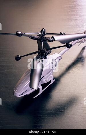 Gray toy helicopter on a wooden table close up Stock Photo