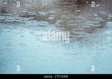 Rain drops on the surface of the water forming ripples Stock Photo