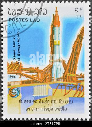 Cancelled postage stamp printed by Laos, that shows Soviet Rocket Soyouz at Baikonur, 10th Anniversary of Apollo and Soyuz, circa 1985. Stock Photo