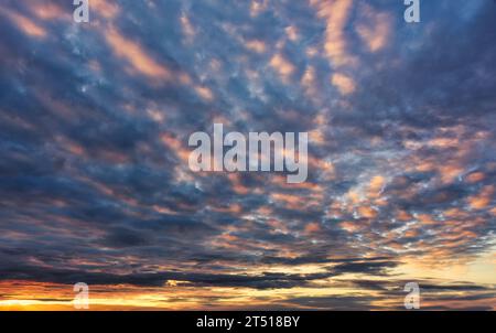 Beautiful vibrant fluffy clouds in sunset sky at twilight Stock Photo