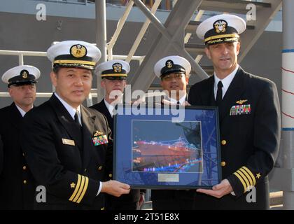 0712204918C-006  YOKOSUKA, Japan (Dec. 20, 2007) Capt. David Lausman, Commanding Officer, USS Blue Ridge (LCC 19) presents Cmdr. Iwasawa Commanding Officer of Japanese warship JS Sawakaze (DDG 170), with a photograph of Blue Ridge decorated with Christmas lights during a gift exchange held on the pier. The holiday gift exchange is done as an expression of mutual respect and good will between the two ships. Blue Ridge is forward deployed to Yokosuka, Japan, and serves as the flagship for Commander U.S. 7th Fleet. U.S. Navy Stock Photo