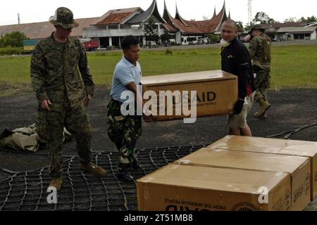 0910124917P-059 PADANG, Indonesia (Oct. 12, 2009) Marines assigned to Combat Logistics Battalion (CLB) 31 of the 31st Marine Expeditionary Unit (31st MEU), Indonesian service members, and Red Cross employees load a cargo net of supplies from The United States Agency for International Development (USAID). The supplies are to be airlifted to remote areas of West Sumatra, Indonesia by CH-53E Super Stallion helicopters from Marine Medium Helicopter Squadron (HMM) 265 (Reinforced). Amphibious Force U.S. 7th Fleet is coordinating U.S. military assistance to victims of the recent earthquakes in West Stock Photo
