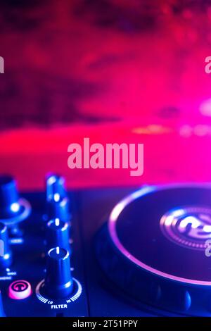 Dj turntables in nightclub electronic music house disco party lights. Stock Photo