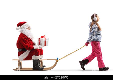 Santa claus holding a present and sitting on a sled pulled by a girl isolated on white background Stock Photo