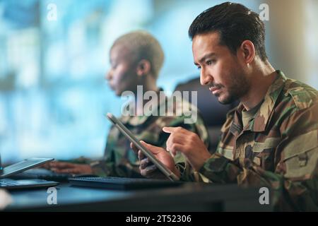 Asian man, army and tablet in surveillance, control room or checking data for military intelligence. Male person, security or soldier working on Stock Photo
