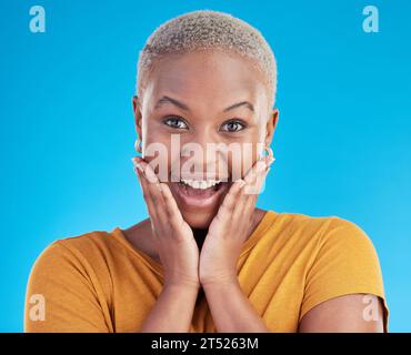 Surprise, portrait and excited black woman in studio for shocking news or deal offer on blue background. Wow reaction, omg and happy female person Stock Photo