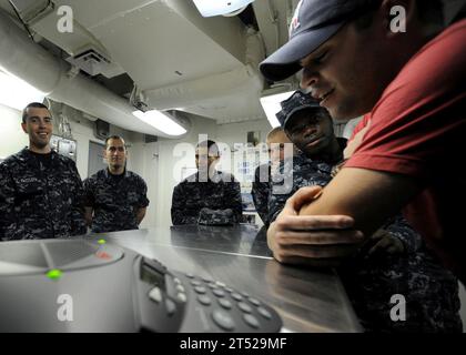 1012248824M-092 U.S. 5TH FLEET AREA OF RESPONSIBILITY (Dec. 24, 2010) Sailors aboard the aircraft carrier USS Abraham Lincoln (CVN 72) gather around a telephone speaker for a holiday phone call with New England Patriots football coach Bill Belicheck, wide receiver Wes Welker and Boston Celtics basketball player Ray Allen. The callers thanked the Sailors aboard Abraham Lincoln and wished everyone a happy holiday. The Abraham Lincoln Carrier Strike Group is deployed to the U.S. 5th Fleet area of responsibility conducting maritime security operations and theater security cooperation efforts. Navy Stock Photo