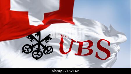 Zurich, CH, Oct. 10 2023: Flags of Switzerland and UBS fluttering in the wind on a clear day. Finance and banking. In March 2023, UBS bought Credit Su Stock Photo