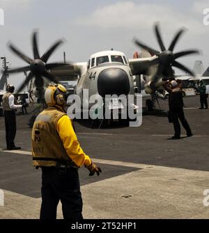 1007106362C-195  5th FLEET AREA OF RESPONSIBILITY (July 10, 2010) A plane director stands by as a C-2 Greyhound, assigned to the Rawhides of  Fleet Logistics Support Squadron (VRC) 40,  is chocked and chained after completing a logistics flight to the aircraft carrier USS Harry S. Truman (CVN 75). The aircraft's primary mission is to transport cargo, mail and passengers between the carrier and shore bases. VRC-40 is deployed as part of the Harry S. Truman Carrier Strike Group supporting maritime security operations and theater security cooperation efforts in the U.S. 5th Fleet area of responsi Stock Photo