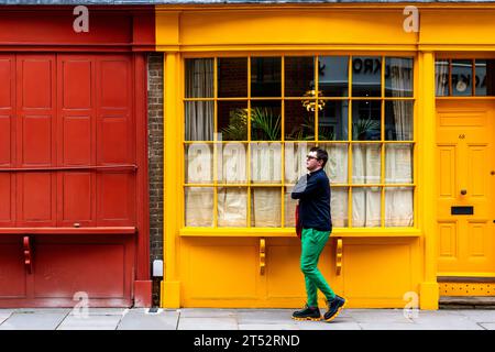 A Young Man Walks Past Some Colourful Property In Bermondsey Street, Bermondsey, London, UK Stock Photo