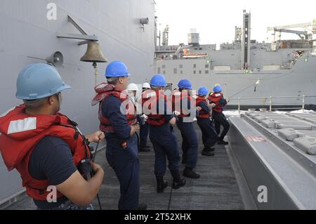 0910099500T-126 GULF OF ADEN (Oct. 9, 2009) Sailors aboard the guided-missile cruiser USS Anzio (CG 68) hold fast to a phone and distance line during an underway replenishment with the Military Sealift Command dry cargo and ammunition ship USNS Amelia Earhart (T-AKE-06) in the Gulf of Aden. Anzio is the flagship of Combined Joint Task Force 151, a multinational task force established to conduct counter-piracy operations off the coast of Somalia. Stock Photo