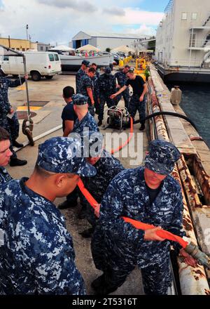 1007280772K-005 SANTA RITA, Guam (July 28, 2010) Sailors assigned to the submarine tender USS Frank Cable (AS 40) practice hose handling and manning a P-100 water pump. Frank Cable is undergoing upgrades at Guam Shipyard for the Military Sealift Command conversion. Stock Photo