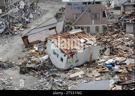 1103152653B-107 OFUNATO, Japan (March 15, 2011) An upended house is among debris in Ofunato, Japan, following a 9.0 magnitude earthquake and subsequent tsunami. Stock Photo