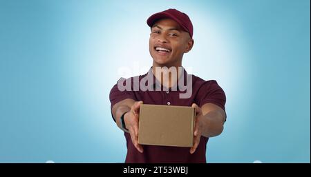 Portrait, happy man and courier with delivery in studio for mock up on blue background in Cape Town. Male model, smile and excited for logistics Stock Photo