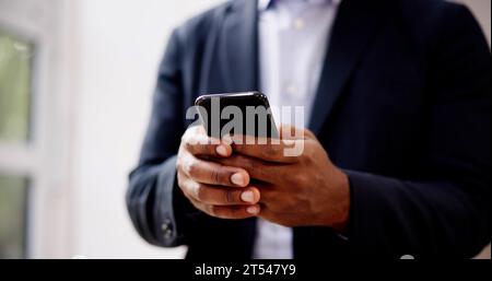 African Man Holding Smartphone Or Mobile Phone Stock Photo
