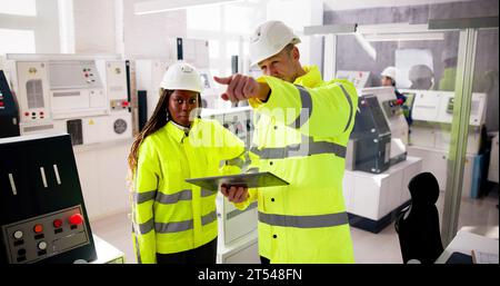 Factory Engineers In Helmets. Checking Industrial Facility Stock Photo