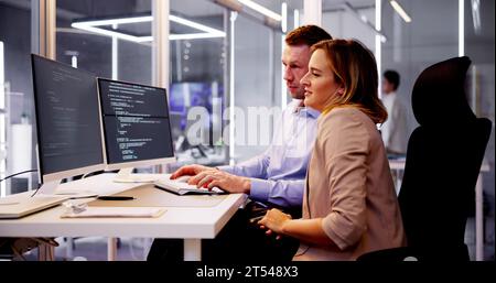 Computer Programmer Writing Program Code On Computer In Office Stock Photo