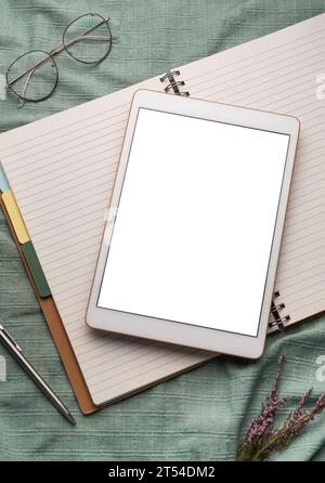 Tablet empty white screen and notebooks  on the office desk Stock Photo