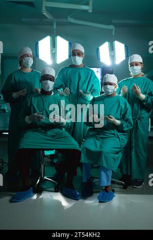 Portrait of diverse surgeons wearing surgical gowns in operating ...