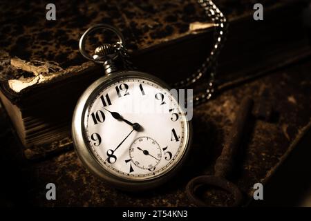 Open pocket watch and a stack of books. Stock Photo