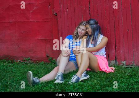 Teen girls lean on each other Stock Photo