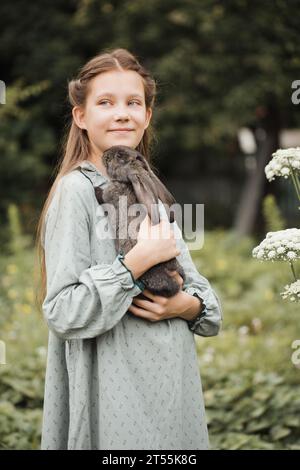 A teenage girl with a rabbit in the garden Stock Photo