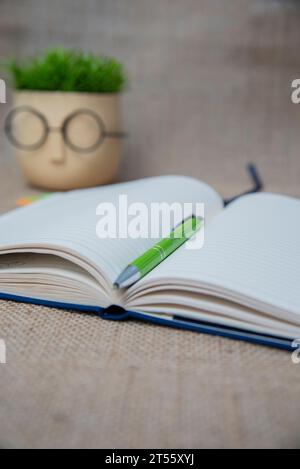 Open blank notepad with empty white pages laying on a table. cozy home setting. Stock Photo