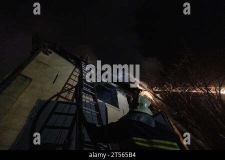 Ukrainian firefighters work to extinguish a fire following an overnight Russian drone strike in Kharkiv on November 3, 2023. Russia launched a massive drone attack early on Friday, hitting critical infrastructure in the west and south of Ukraine and destroying private houses and commercial buildings in Kharkiv, Ukraine's second largest city, officials said. The air force said it shot down 24 'Shahed' drones out of 40 launched by Russia, the biggest drone attack in weeks to target Kharkiv in the northeast, Odesa and Kherson in the south and the region of Lviv on Ukraine's border with Poland in Stock Photo