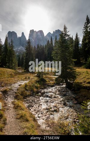 Scenic view of Wasserkofel, Furchetta Grande mountain (left to right) along hiking trail and Rio San Zenon in South Tyrol, Italy against bright sky Stock Photo