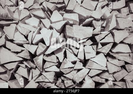 Stack of firewood, black and white. Chopped logs background. Woodpile background, monochrome. Stacked wood. Logging storage. Harwood background. Stock Photo
