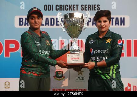 Captains of Bangladesh and Pakistan women cricket team Nigar Sultana Joty (L) and Nida Dar (R) unveil the One Day International (ODI) series Trophy at Stock Photo