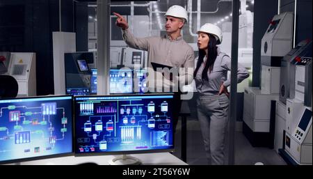 Factory Engineers In Helmets. Checking Industrial Facility Stock Photo