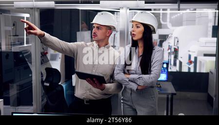 Factory Engineers In Helmets. Checking Industrial Facility Stock Photo