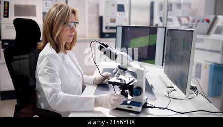Female Worker in an Electronic Factory Using Computer in Lab Stock Photo