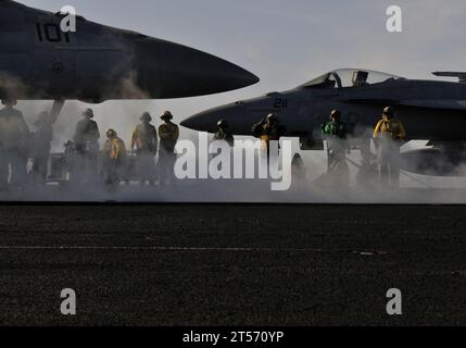 US Navy An aircraft director guides an F18F Super Hornet into position for launch from the bow catapults aboard the Nimitz-cl.jpg Stock Photo