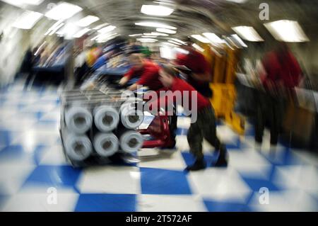 US Navy Aviation Ordnancemen from the weapons department aboard the Nimitz-class aircraft carrier USS Theodore Roosevelt (CVN 71) move ordnance.jpg Stock Photo