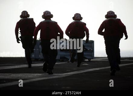 US Navy Aviation Ordnancemen assigned to Weapons Department's G-1 Division run to retrieve crates of ordnance aboard the Nimitz.jpg Stock Photo