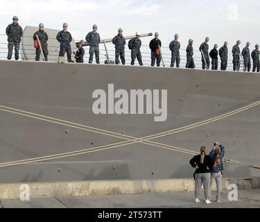 US Navy Family members take pictures of the crew of the guided-missile destroyer USS Milius (DDG 69) manning the rails in prepar.jpg Stock Photo