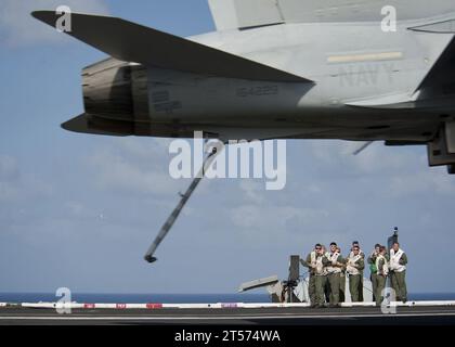 US Navy Landing signal officers supervise the arrested recovery of an F18C Hornet on the flight deck aboard the Nimitz-class.jpg Stock Photo