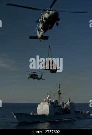 US Navy MH-60S Sea Hawk helicopters assigned to Helicopter Anti-Submarine Squadron (HSC) 23 deliver supplies.jpg Stock Photo