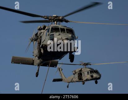 US Navy MH-60S Sea Hawk helicopters assigned to Helicopter Anti-Submarine Squadron (HSC) 23 deliver supplies to the flight deck.jpg Stock Photo