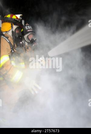 US Navy Navy Region Northwest Fire and Emergency Services Team firefighters conduct a live-fire training exercise inside a mobile.jpg Stock Photo